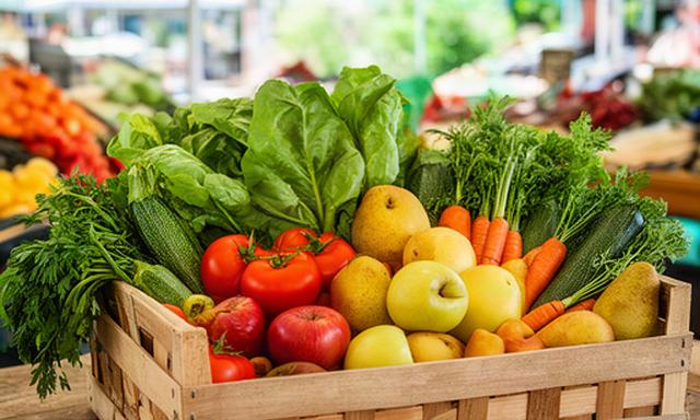 Cassetta con frutta e verdura fresca della Romagna in un mercato locale luminoso