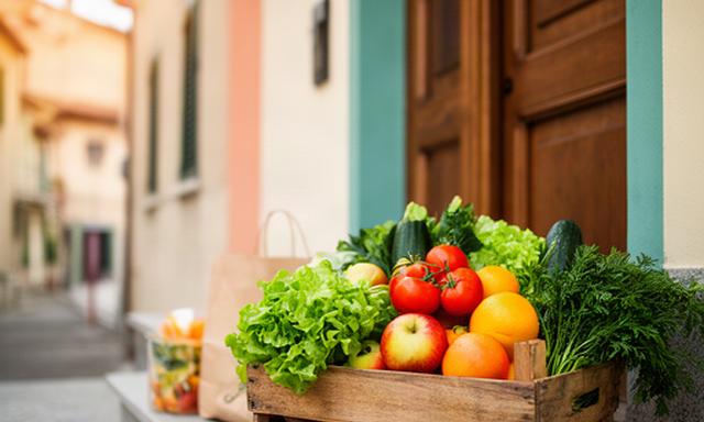 Cassetta di frutta e verdura fresca consegnata davanti a una casa di Faenza